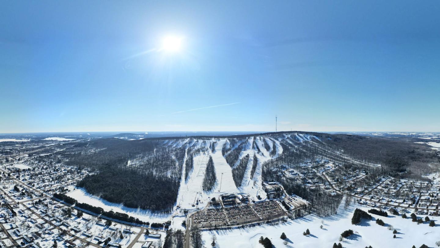 An aerial drone photograph of Granite Peak Ski Area covered in snow on a bluebird sunny day in the middle of winter,