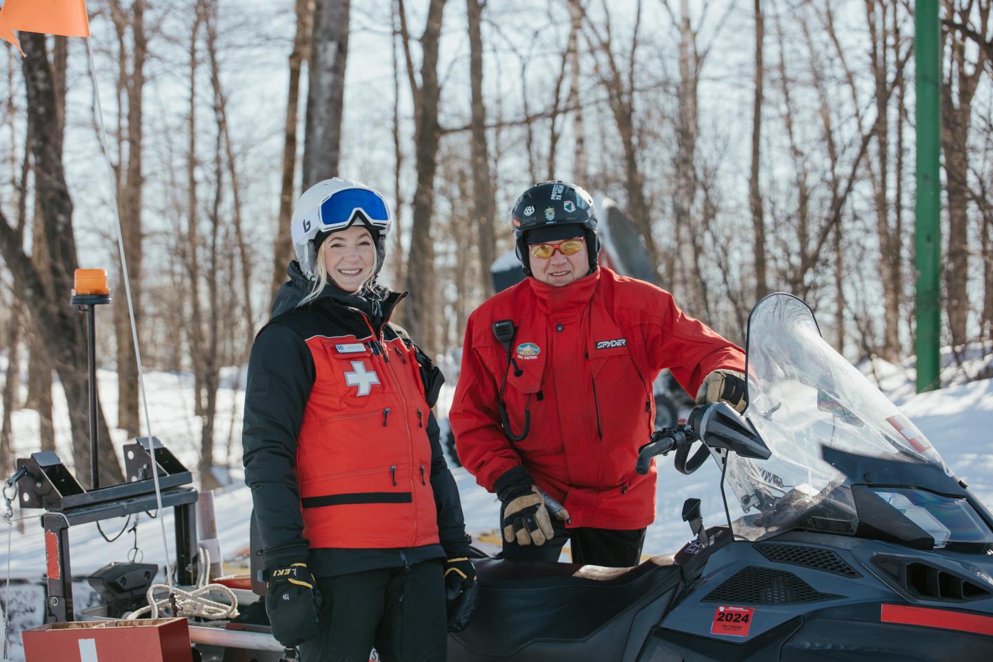two ski patrollers smiling