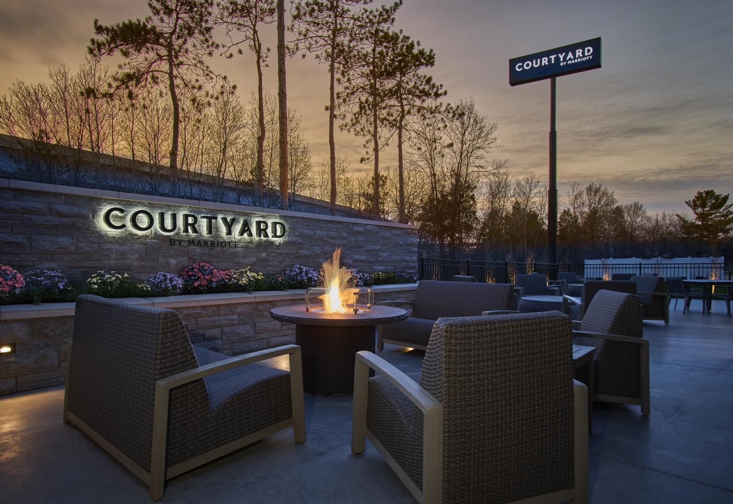 Outdoor seating area at sunset with a fire pit and comfortable chairs.