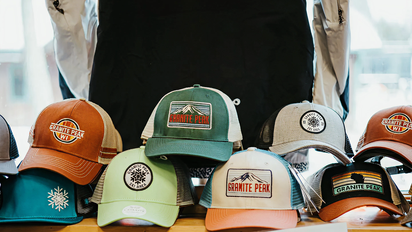 Caps with various logos and colors displayed on a tabletop.