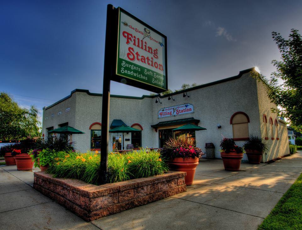 Restaurant exterior with plants, clear sky.