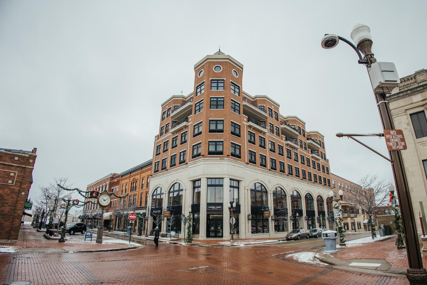 Historic brick building on a snowy street corner under a gray sky.