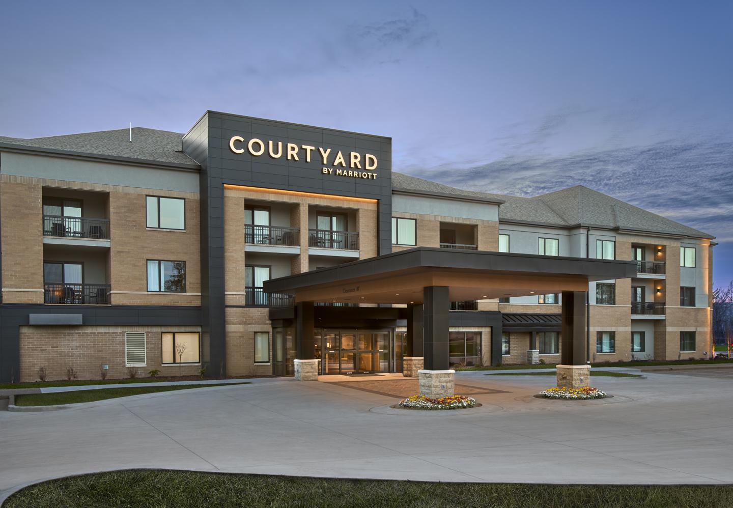 Courtyard hotel entrance at dusk with modern architecture.