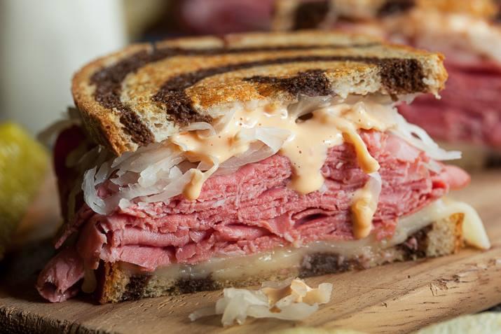 Reuben sandwich with corned beef, sauerkraut, and dressing on marble rye.