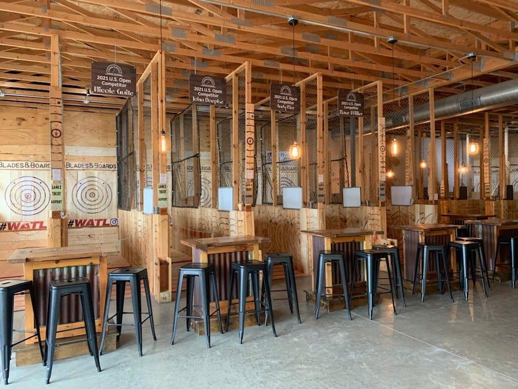 Wooden tables and stools in a rustic restaurant interior with exposed beams.