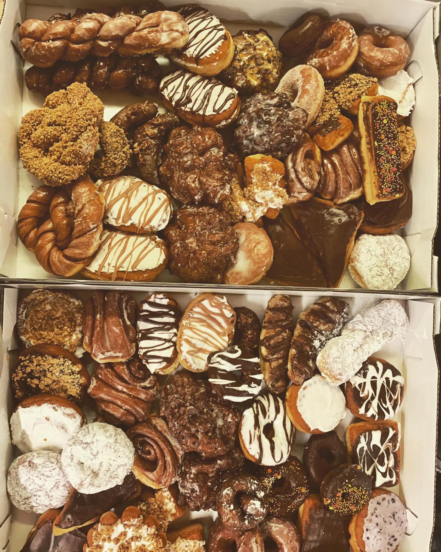 Assorted donuts in two boxes, featuring various flavors and toppings.