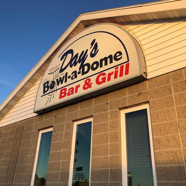 Bowl-a-Dome Bar & Grill sign on building facade at sunset.