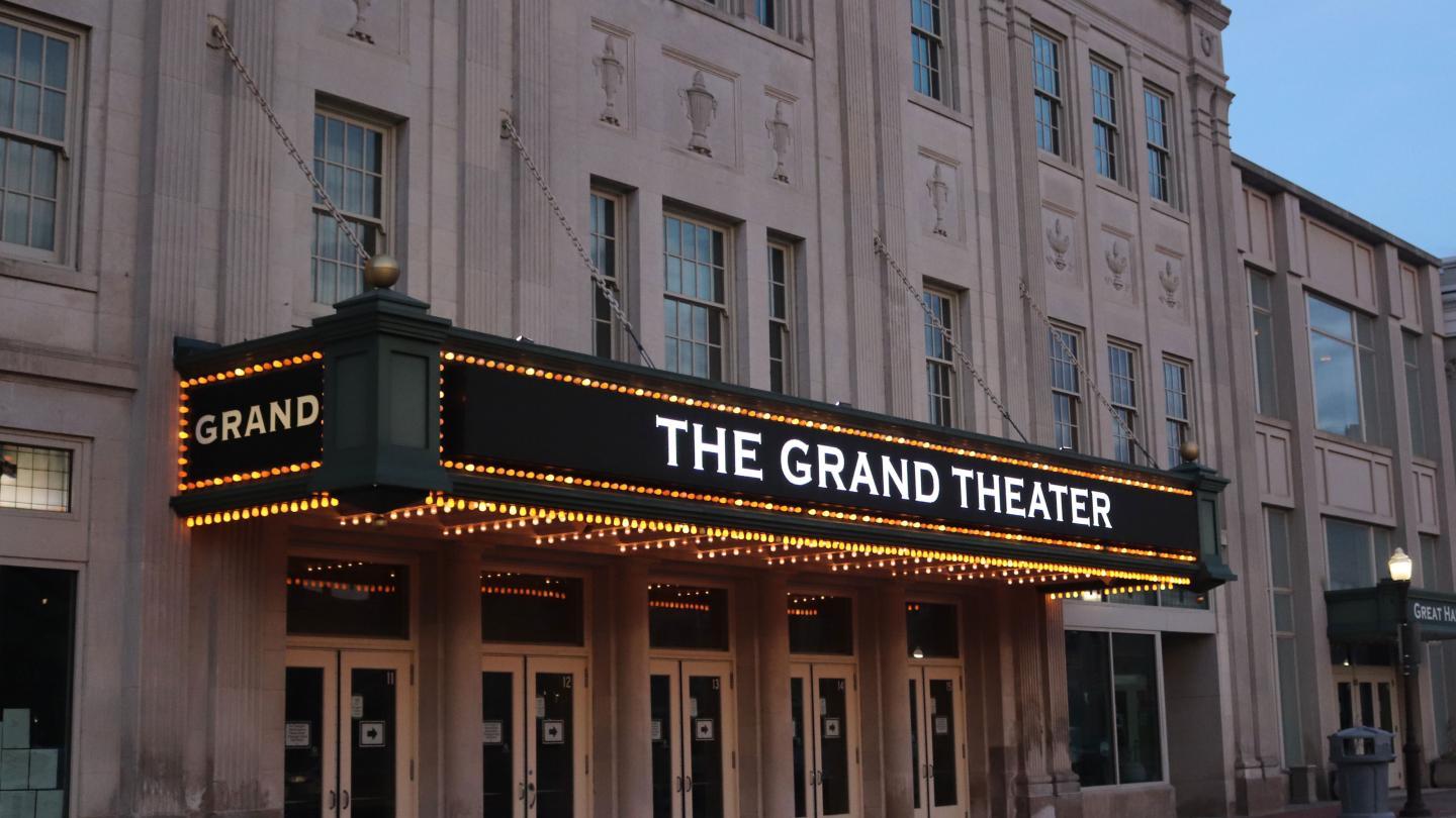 The Grand Theater facade with lit marquee at twilight.
