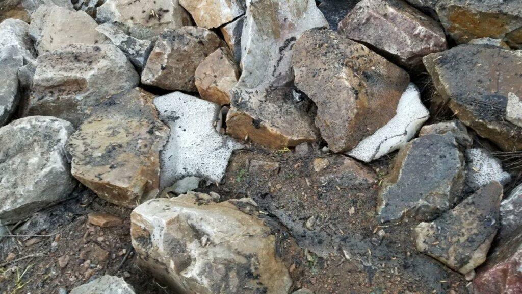 Rocks of various sizes and colors on a dirt surface.