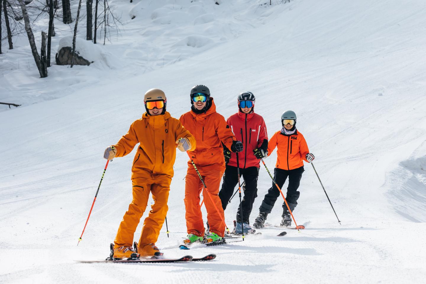 Skiers in colorful gear on a snowy slope.